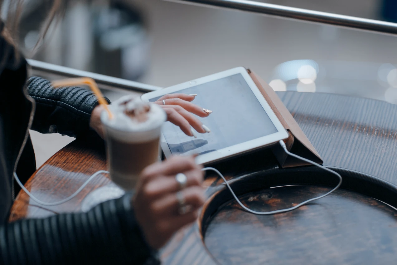 Mãos interagindo com uma interface em tablet
